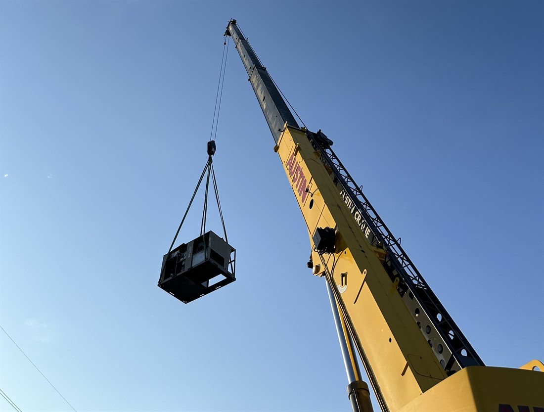 Crane setting a rooftop HVAC unit on a commercial building in Austin, Texas